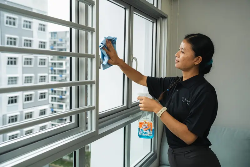 A Cleancraft cleaner wiping down a window frame in an HDB flat